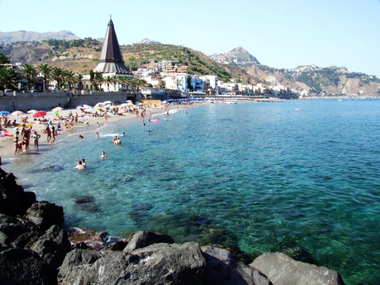 Udsigt over blåt badevand og turister i Messina